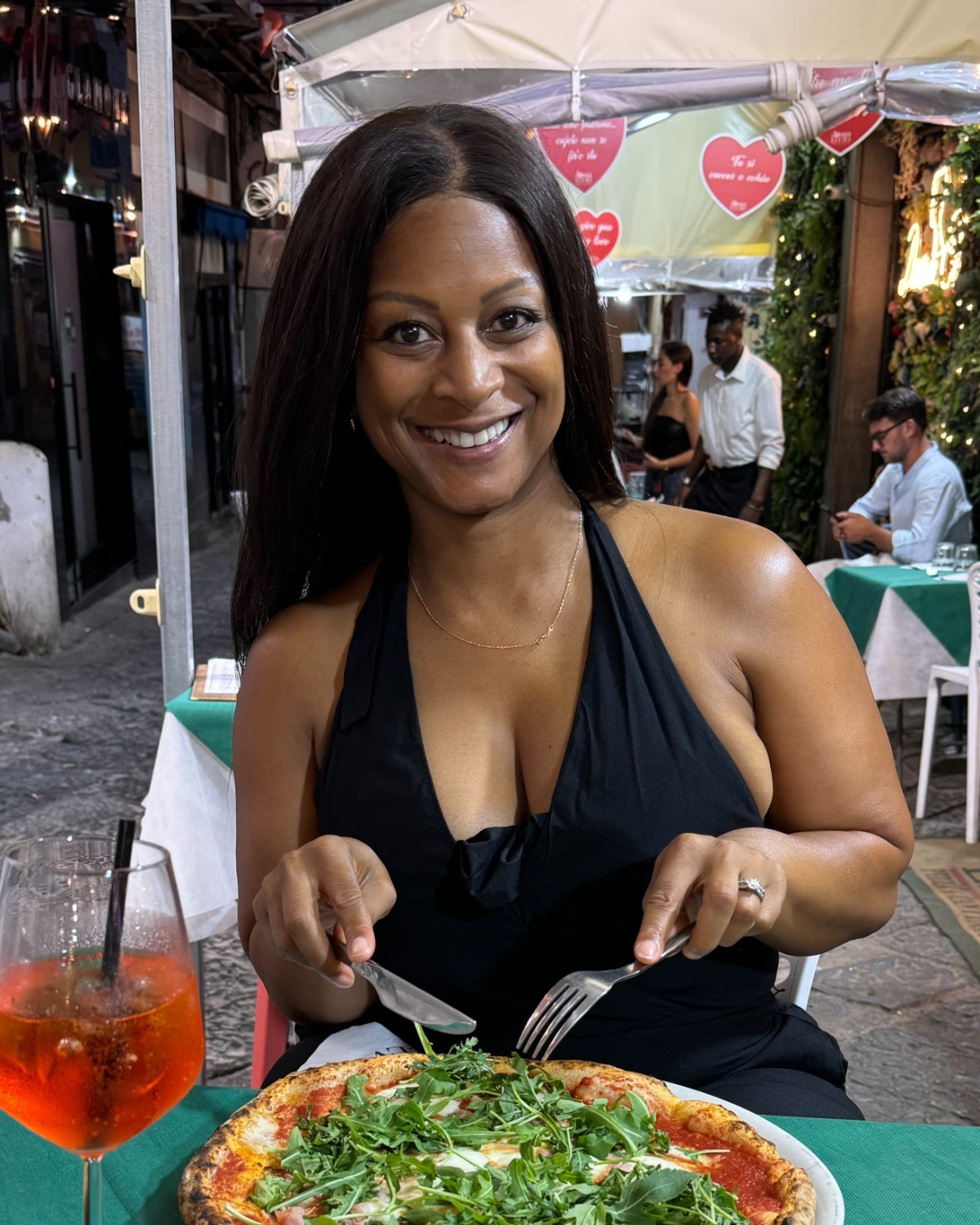 Jeia Lauria at an outdoor pizzeria table in Italy
